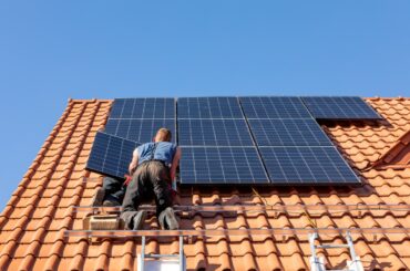 Ochojno, Poland - April 8, 2020: Workers installing solar electric panels on a house roof in  Ochojno. Poland